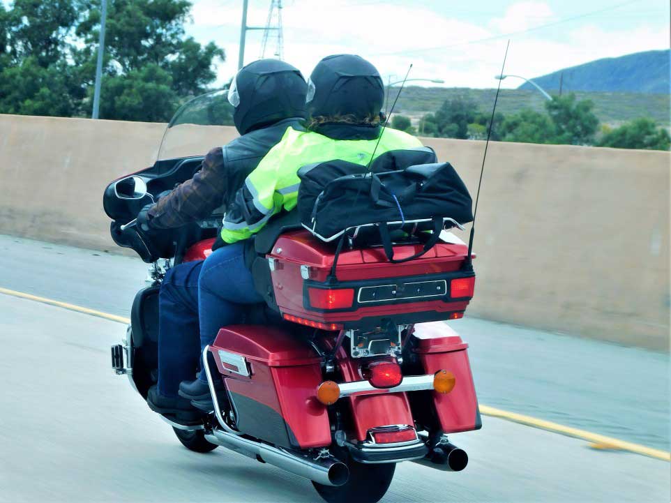 couple riding their honda motorcycle with a windshield